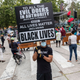 Isadore Henry of Los Angeles holds a sign during the Juneteenth celebration on Friday, June 19, 2020, in Leimert Park, CA.